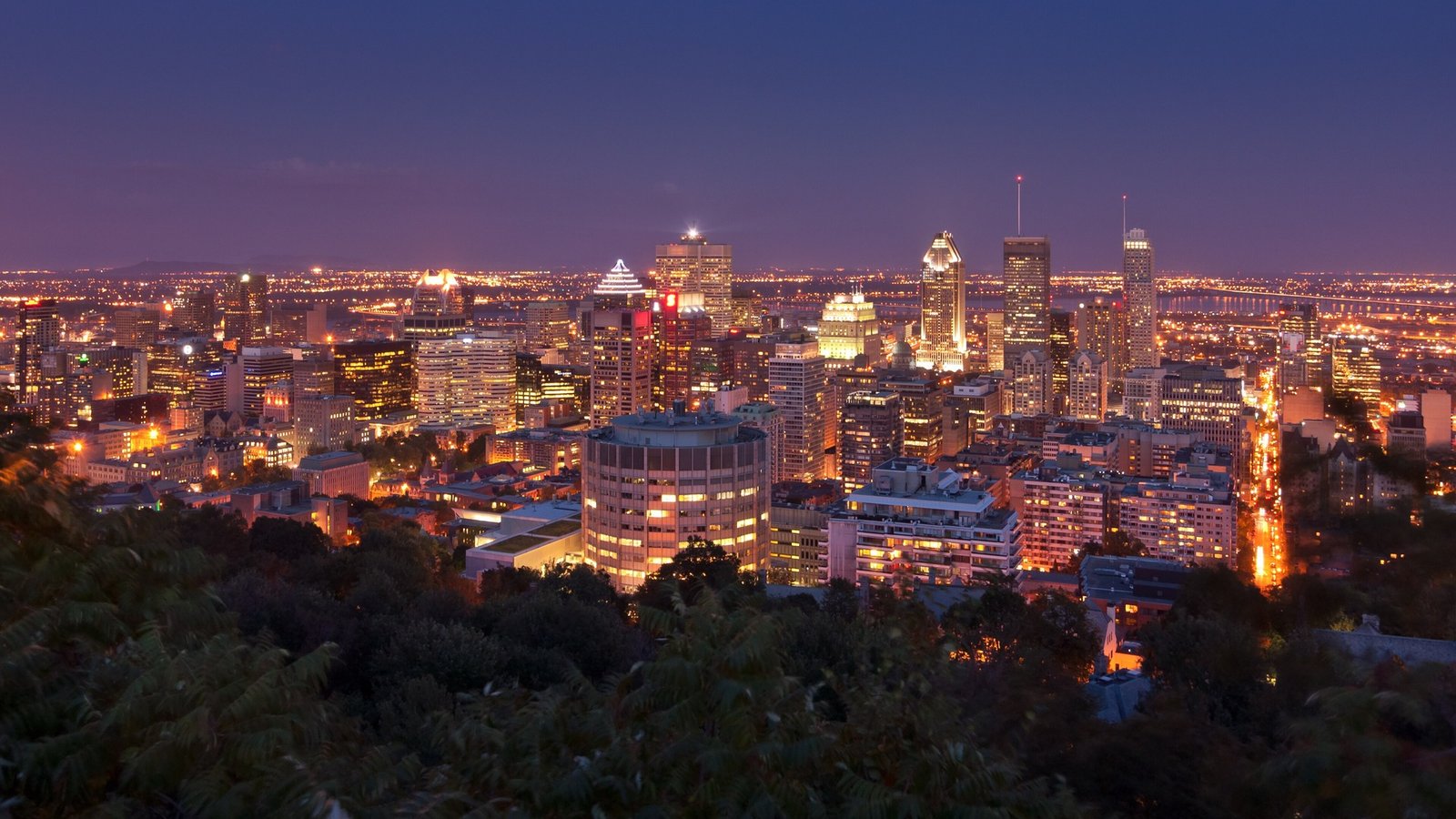 The stone semi-circular Kondiaronk Belvedere lookout at Mount Royal Chalet, with visitors at the railing overlooking the city