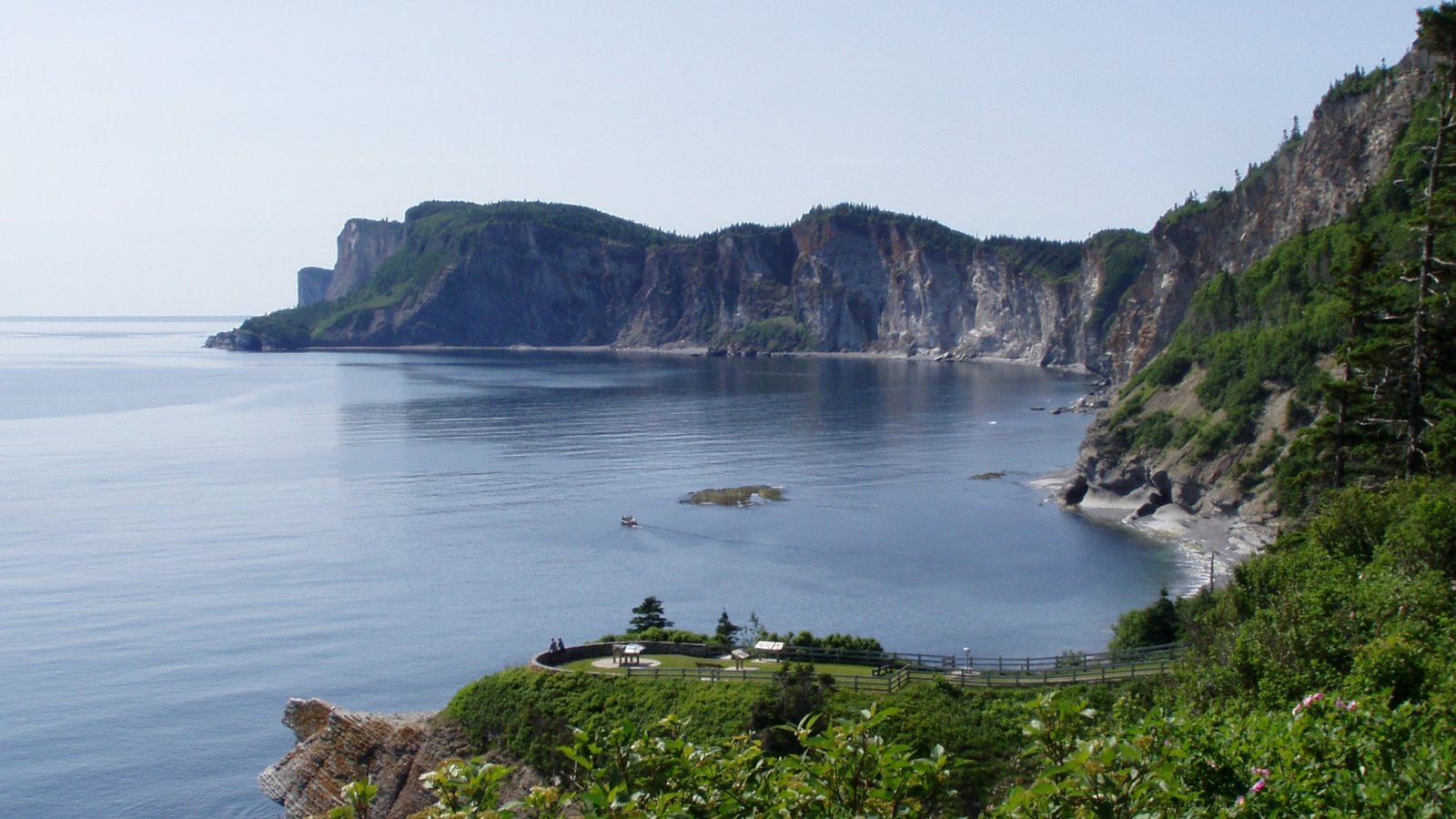 Sheer pale limestone cliffs dropping into open ocean at Forillon National Park, Gaspé Peninsula